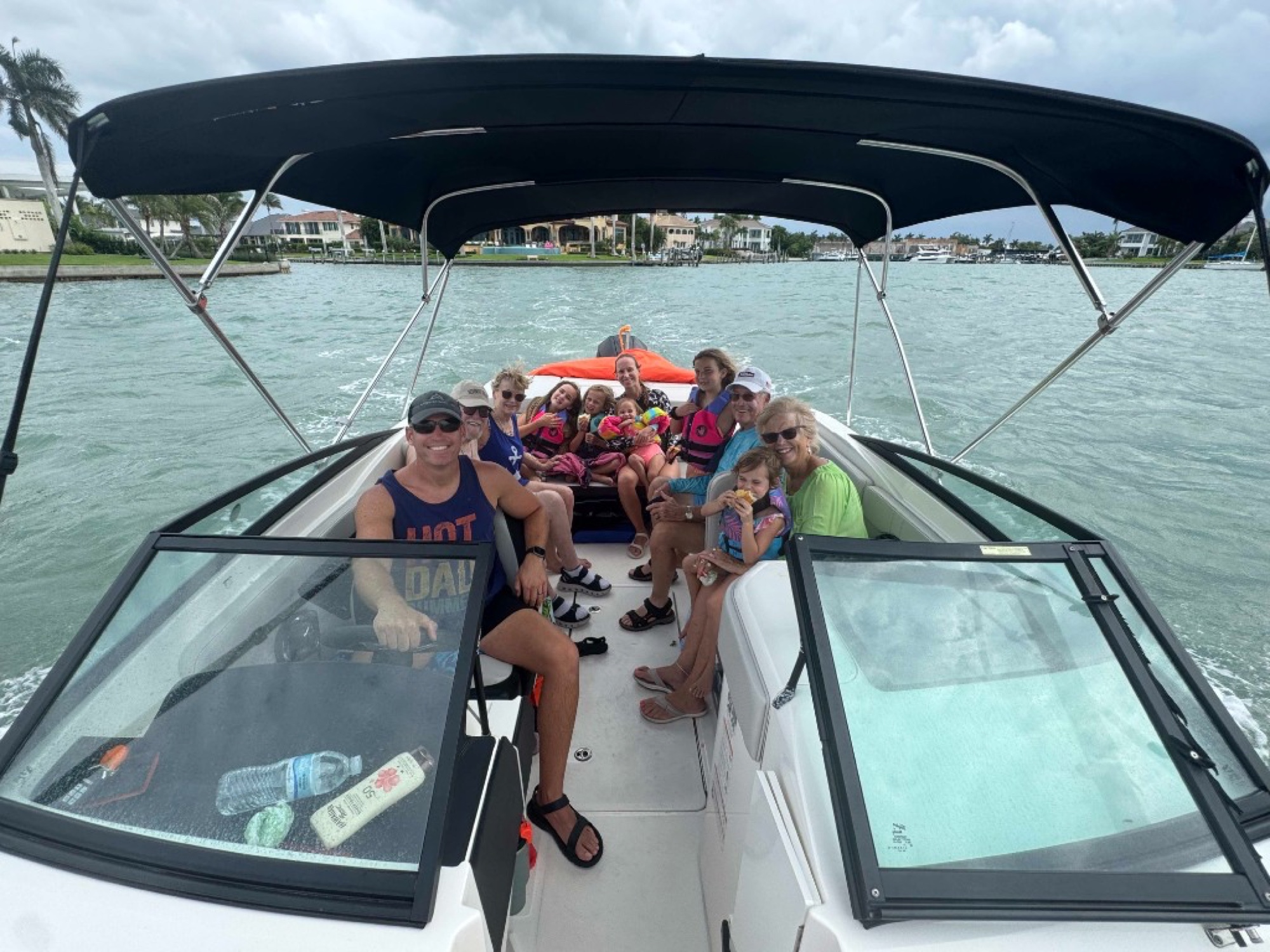 Family boat day with the waterfront homes behind them